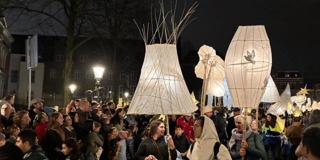 Verlichte grote lampenkappen in een optocht