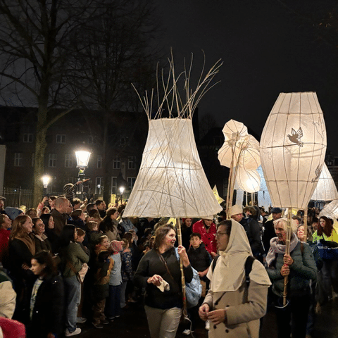 Verlichte grote lampenkappen in een optocht