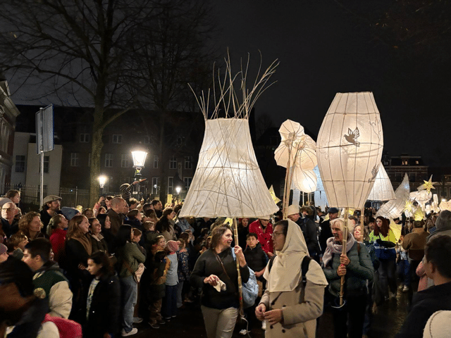 Verlichte grote lampenkappen in een optocht